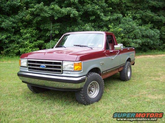 1990 Ford F-150 pickup truck parked on grass with trees in background
