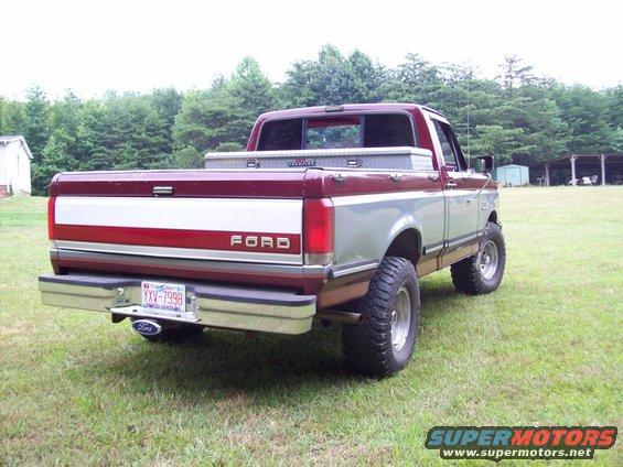 Maroon and silver Ford F-150 pickup truck with a toolbox in the bed, lifted suspension, and aftermarket wheels