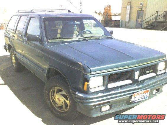 1995 GMC Jimmy SUV front 3/4 view, dark green paint, gold wheels, license plate visible