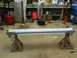 1993 Ford Bronco - A car rocker panel is supported by jack stands in a garage setting with tools and equipment in the background.