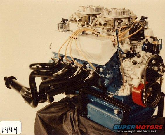 Ford V8 engine with dual carburetors and headers, mounted on a stand