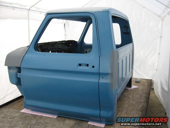 Blue 1977 Ford F-150 cab and bed in a tent, 3q-front view