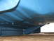 1977 Ford F-150 - The underside of a blue 1977 Ford F-150 reveals its frame and floor pan construction, with visible Supermotors.net branding.