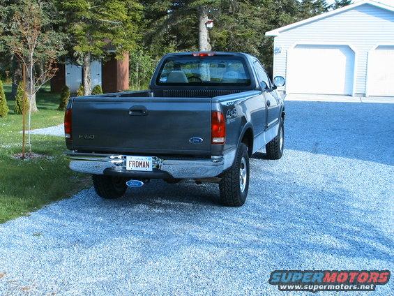 Rear view of a dark gray 1999 Ford F-150 pickup truck parked on a gravel driveway