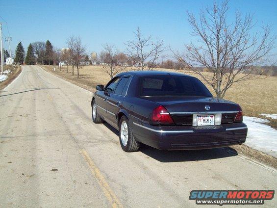 Dark sedan parked on a rural road, showing its rear