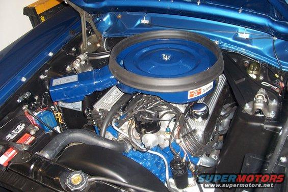 Blue engine bay with V8 engine, air cleaner, and battery