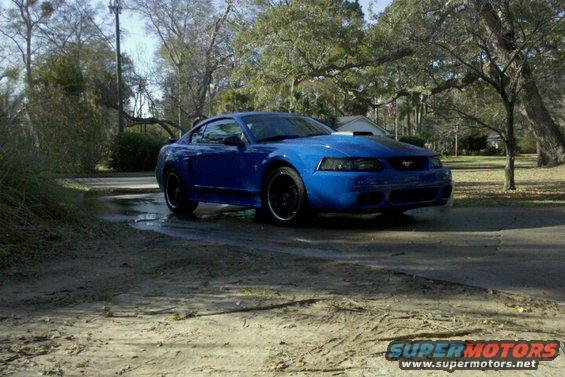 Blue coupe with black wheels and a hood scoop, angled from the front-right