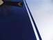 2010 Chevrolet Camaro - Close-up of a car hood showing dark blue paint with silver racing stripes and a reflection.