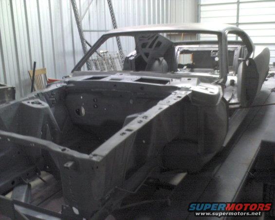 1970 Ford Mustang body shell, bare metal, in a workshop, 3q-front view