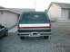 1988 Ford Bronco - The rear of a Ford Bronco is shown, a two-tone paint scheme with a red accent stripe.