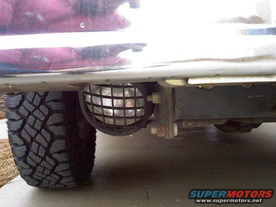 Front fog light with protective grille on a vehicle