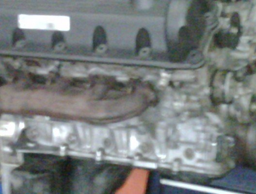 Engine block with exhaust manifold and some wiring visible