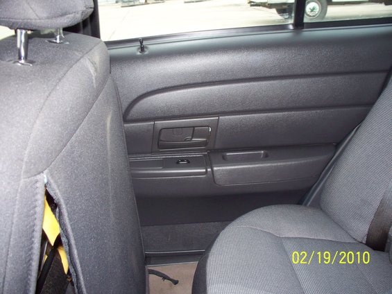 Rear door panel and seats of a dark-colored vehicle with a date stamp of 02/19/2010