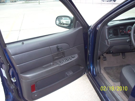 Driver's side door open showing interior, dashboard, and part of the steering wheel. Date stamp reads 02/19/2010