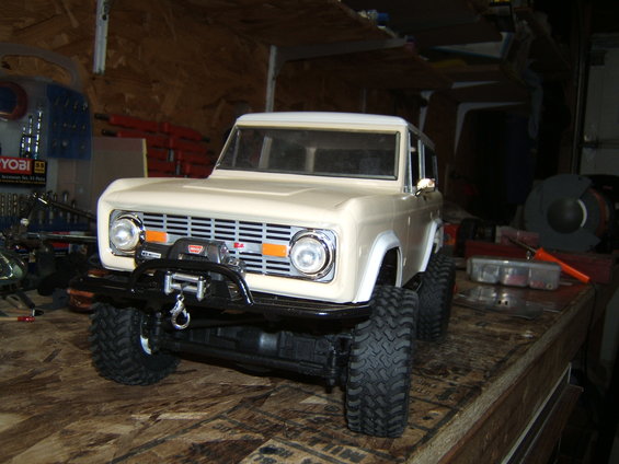 Cream-colored RC car model with a winch on the front bumper, parked on a wooden surface