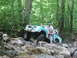 1969 Ford Bronco - Modified 1969 Ford Bronco tackling a challenging rocky trail in the woods.