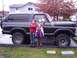 1979 Ford Bronco - A dark blue 1979 Ford Bronco is shown from the side with two children posing in front of it.