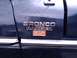 1979 Ford Bronco - Close-up of the Bronco Ranger XLT badge on a dark blue vehicle.