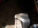 1997 Ford Ranger - A close-up view of a rusty metal part, likely a vehicle suspension component, secured in a vise.