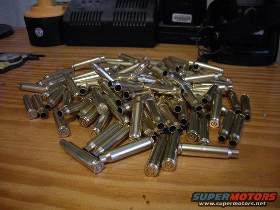 Pile of spent bullet casings on a wooden surface