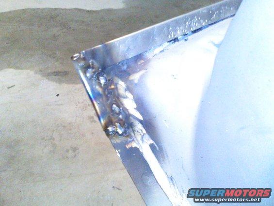 Welded metal panel with visible weld marks and a light blue surface