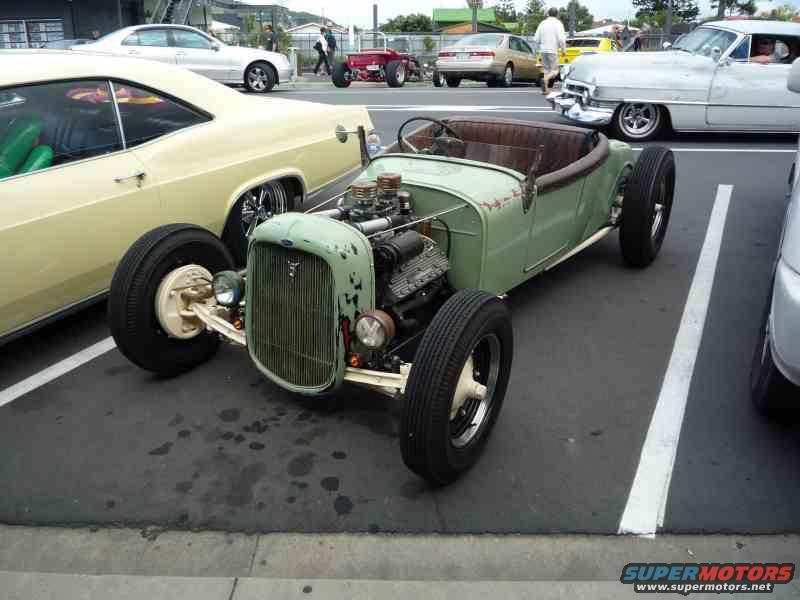 Green hot rod with exposed engine, custom build, front view