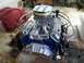 1966 Ford E100 - A V8 engine with chrome valve covers and air cleaner is installed in a vehicle's interior.