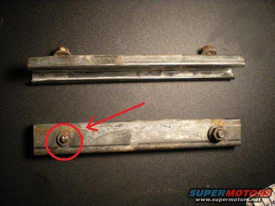 Two metal tailgate brackets, one with a red circle around a bolt
