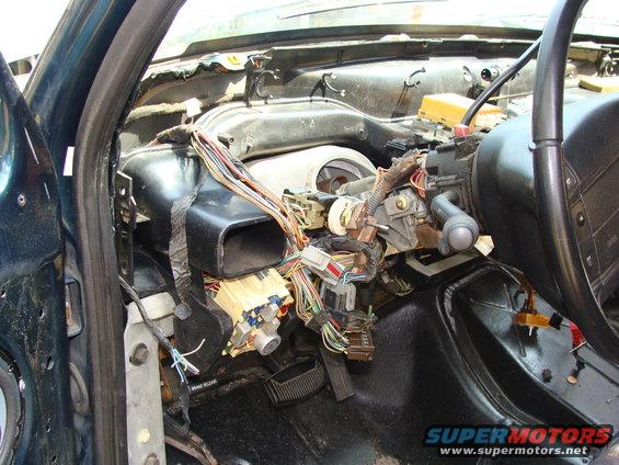 1994 Ford Bronco interior with dashboard removed, showing wiring harness and steering column