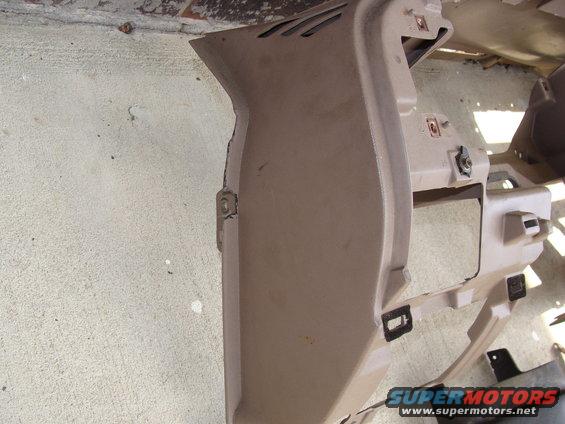tan dashboard trim piece with vents and mounting points