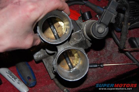 Dual throttle body with visible butterfly valves and a Sharpie marker nearby