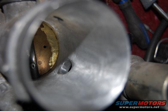 Close-up view inside a throttle body, showing the butterfly valve and bore