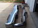 1973 Ford Ranchero - Two chrome bumpers are laid out on a driveway, possibly for restoration or sale.