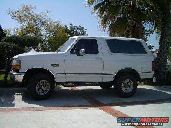 White 1992 Ford Bronco SUV parked on a paved driveway, side view
