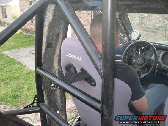 Interior view of a vehicle with a roll cage and Corbeau seats