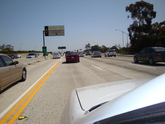 driving on a highway with multiple cars and a carpool lane sign