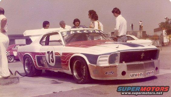 White and red race car with number 13, Goodyear tires, and Ford branding