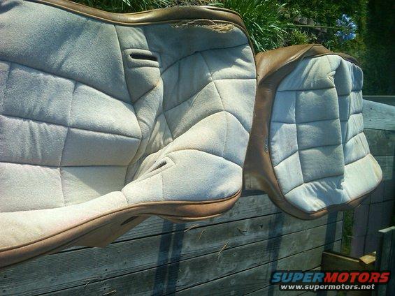 Two quilted car seats with brown trim, one showing damage at the top