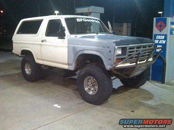 Lifted Ford Bronco with primer gray fender and hood, BFGoodrich sticker on windshield