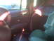 1993 Lincoln Town Car - The interior of a car features maroon upholstery and a child safety seat, with a view of the road through the window.