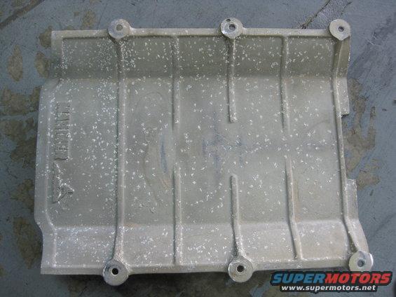 Aluminum part with bolt holes and ribbed surface. Text visible on left