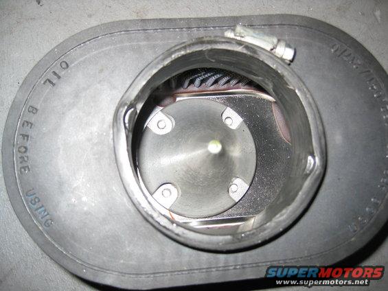 Close-up of an air filter housing with 'OIL BEFORE USING' text visible