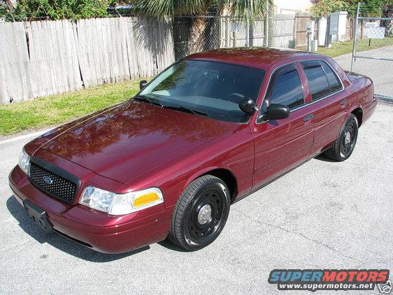 Maroon Ford Crown Victoria with black grille and steel wheels, parked on asphalt