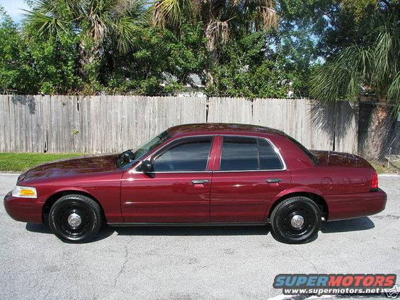 Side view of a maroon Ford Crown Victoria with black steel wheels