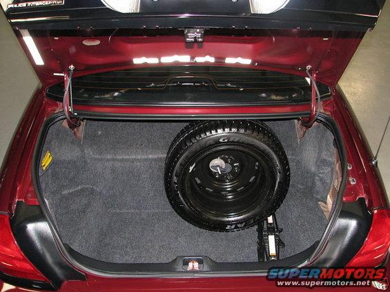 Trunk of a 2005 Ford Crown Victoria showing spare tire and jack