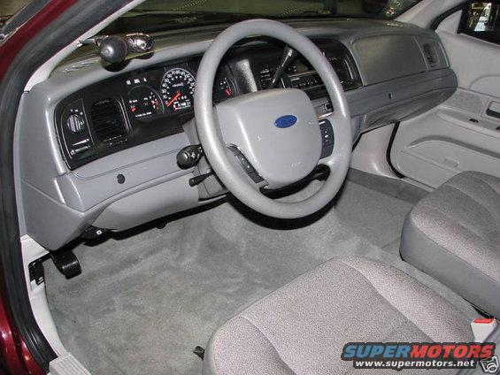 Gray interior of a 2005 Ford Crown Victoria showing dashboard, steering wheel, and seats