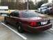 2005 Ford Crown Victoria - Maroon sedan parked in a lot with trucks in the background, showing its rear quarter.