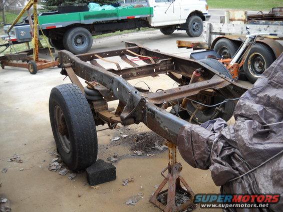 54-build--33010-002.jpg After I got the hitch out of the way I was able to get to the last two rivots holding the last crossmember in place.  After I took care of the last two rivots I pulled the crossmember out. Then I took the grinder and cut off the last bolt on the other crossmember. Once that bolt was out of the way I was able to pull that crossmember out.

Next I moved the crossmember to the truck frame and set them in place. And big surprise they are going to need to modifications to work in the new locations. The rear most crossmember is going to need to be modified so I can mount it. And the other crossmember is too short for the frame rails. I plan to run a gas tank out of a fullsize Bronco. So I am going to leave these crossmembers until I can get the tank I'm going to run. This way I won't have to redo the crossmembers if the tanks dimensions are different.

After I was done messing with the rear crossmembers I moved to the crossmember at the rear spring front mounts. I used a couple holes, left over from one of the crossmembers I removed, to locate the crossmember. I then sat it on top of the frame rails and marked the remaining four holes. Next I double checked the frame width to make sure I didn't need to pull the rails in. It was right on the mark. So I drilled out the holes. Then I moved the crossmember back to the underside of the top frame lip and bolted it in place. Once it was in place then I installed the two end braces. 
