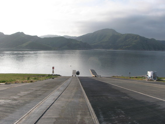 Boat ramp leading to a lake with a small boat near the water
