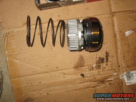 Disassembled shock absorber with spring and housing on cardboard